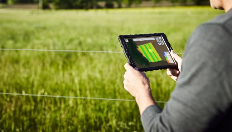 Imagem mostra um produtor analisando um mapa de produtividade da colheita 